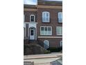Close-up of the brick townhome featuring black iron details and a raised entrance, enhancing the property's curb appeal at 5139 Peachtree Road, Chamblee, GA 30341