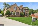 Beautiful two-story brick home with well-manicured lawn and mature trees at 3835 Hickory Branch Trl, Suwanee, GA 30024