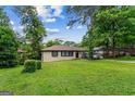 Inviting single-story home with a well-manicured lawn and mature trees providing shade at 2835 Laguna Dr, Decatur, GA 30032
