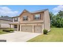 Side view of a brick and siding home featuring a well-kept lawn and an attached three-car garage at 8041 Louis Dr, Locust Grove, GA 30248