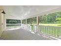 A covered porch featuring white railings and views of the surrounding trees and well-manicured lawn at 465 Haynie Rd, Moreland, GA 30259