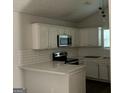 Modern kitchen featuring white cabinets, quartz countertops, and stainless steel appliances at 135 Green Commons Dr, Covington, GA 30016