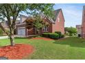 Charming two-story brick home with a well-manicured lawn and mature tree at 1979 Spivey Village Dr, Jonesboro, GA 30236