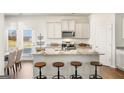 Modern kitchen with stainless steel appliances, granite countertops, an island with stools, and a breakfast area at 11893 Aukerman Way, Hampton, GA 30228