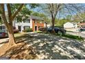 View of townhouses with mature trees and driveways, creating a serene and welcoming environment at 5599 Fair Creek Way, Lithonia, GA 30038
