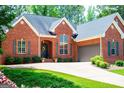 Charming brick home featuring an attached garage, neatly trimmed bushes, and lovely curb appeal at 109 National Way, Carrollton, GA 30116