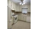 Bright kitchen features tile flooring, white appliances and cabinetry, plus a ceiling fan at 207 Oak N Cir, Stockbridge, GA 30281