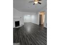 Spacious living room with a fireplace, ceiling fan and dark wood-look floors at 2985 Garnet Way, South Fulton, GA 30349