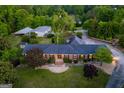 Aerial view of a home showcasing its brick facade, well-manicured lawn, and surrounding lush landscaping at 3700 Tom Brewer Road, Loganville, GA 30052