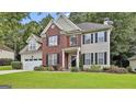 Lovely two-story home boasting a brick and siding exterior, black shutters, and an attached garage, all on a well-maintained lawn at 139 Ardenlee Dr, Peachtree City, GA 30269