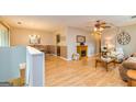 Open-concept living room features light wood floors, fireplace, ceiling fan, dining area, and neutral color palette at 44 Twiggs Cor, Peachtree City, GA 30269