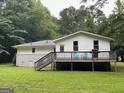 Back exterior of home features a spacious wooden deck with railing, offering views of the green backyard at 616 Inman Rd # B, Fayetteville, GA 30215