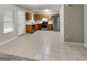 Well-lit kitchen features stainless steel appliances, wood cabinets, and tile flooring at 6630 Pole Creek Dr, Lithonia, GA 30058