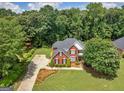 Spacious property showcasing a brick home with lush landscaping and surrounding mature trees at 4147 Alayna Lee Cir, Mcdonough, GA 30252