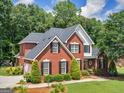 Traditional brick home featuring mature trees, a circular driveway, and manicured landscaping at 4147 Alayna Lee Cir, Mcdonough, GA 30252