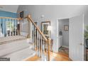 Inviting foyer with wooden staircase, hardwood floors, and neutral paint scheme at 4147 Alayna Lee Cir, Mcdonough, GA 30252