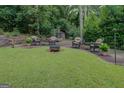 Serene backyard featuring lush lawn, outdoor seating area with fire pit, perfect for entertaining at 4187 Cherry Laurel Se Dr, Covington, GA 30014