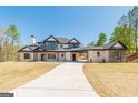 Beautiful two-story home featuring stone and modern architectural details with an expansive driveway at 105 Robinwood Ct, Fayetteville, GA 30214
