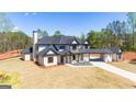 Expansive two-story home boasting a black roof, sleek design, and long private driveway at 105 Robinwood Ct, Fayetteville, GA 30214