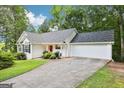 Inviting white home features a well-maintained lawn and a two-car garage at 345 Sharon Dr, Fayetteville, GA 30214