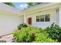 Cozy front porch with red door, white railings, and decorative hanging lanterns at 345 Sharon Dr, Fayetteville, GA 30214