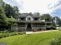 Traditional-style home with a well-manicured lawn and a welcoming front porch at 3970 Governors Cir, Loganville, GA 30052