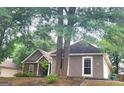 Single Gathering house featuring a stone accent wall, stucco siding, an attached garage, mature trees, and landscaping at 455 Old Ivy Path, Mcdonough, GA 30253