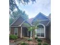 Well maintained house with a stone accent wall, arched window, covered entryway, and tidy landscaping under a beautiful sky at 455 Old Ivy Path, Mcdonough, GA 30253