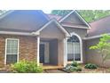 Charming home featuring a stone facade, stucco accents, a covered porch, and arched window, surrounded by established landscaping at 455 Old Ivy Path, Mcdonough, GA 30253