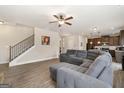 Open-concept living room with hardwood floors, ceiling fan, and a staircase leading to the upper level at 2277 Church St, Hampton, GA 30228