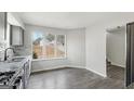 Bright kitchen boasts stainless appliances, granite counters, backsplash, and a view of the backyard through large windows at 5368 Nw Stafford Nw Dr, Lilburn, GA 30047