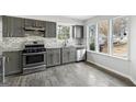 Updated kitchen featuring stainless steel appliances, subway tile backsplash, and bright natural light through large windows at 5368 Nw Stafford Nw Dr, Lilburn, GA 30047