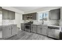 Updated kitchen featuring gray cabinets, subway tile backsplash, stainless steel appliances, and granite countertops at 5368 Nw Stafford Nw Dr, Lilburn, GA 30047