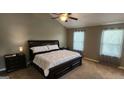 Spacious main bedroom with a large bed, ceiling fan, and natural light from two windows at 305 Hidden Creek Ln, Canton, GA 30114