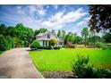 Spacious front yard with lush green lawn and charming two-story home surrounded by mature trees at 204 Pinehurst Way, Carrollton, GA 30116