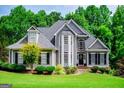 Charming two-story home featuring mature landscaping, a manicured lawn, and a welcoming front porch at 204 Pinehurst Way, Carrollton, GA 30116