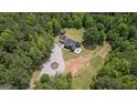 Aerial view of modern black home surrounded by lush trees and land at 500 Happy Hollow Rd, Villa Rica, GA 30180