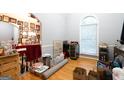 Bright, light-filled room with hardwood floors and an arched window; needs decluttering at 1858 Mcconnell Rd, Grayson, GA 30017