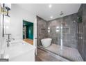 Modern bathroom featuring a soaking tub, glass-enclosed shower, dual vanity, and stylish tile work at 32 Walthall Ne St # A, Atlanta, GA 30307