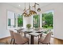 Bright dining room featuring large windows, modern lighting fixture, and an elegant dining set at 32 Walthall Ne St # A, Atlanta, GA 30307