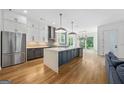 Spacious kitchen with stainless steel appliances, a large island, hardwood floors, and modern fixtures at 32 Walthall Ne St # A, Atlanta, GA 30307