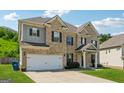 Attractive two-story home boasts a brick facade, gray siding, two-car garage and well-maintained landscaping on a sunny day at 3711 Wartrace Dr, South Fulton, GA 30331