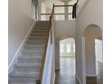 Inviting foyer with staircase featuring wood railing and an open view to the upstairs landing at 1238 Polk Xing, Mcdonough, GA 30252
