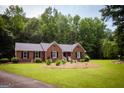 Beautiful brick home with a lush green lawn and lovely garden beds at 155 Granby Ln, Fayetteville, GA 30215