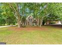 Two story brick house with manicured front lawn, showcasing mature landscaping and welcoming curb appeal at 595 Mcgarity Dr, Mcdonough, GA 30252