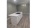 Kitchen island featuring white cabinets and drawers with quartz countertops at 6266 Auburn Dr, Riverdale, GA 30296
