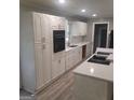 Modern kitchen boasts white cabinets, quartz countertops, and stainless steel appliances at 6266 Auburn Dr, Riverdale, GA 30296