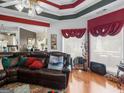 Bright living room featuring hardwood floors, decorative ceiling, large windows, and comfortable leather seating at 141 Wexford Ct, Stockbridge, GA 30281