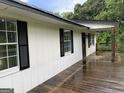 Side view of home featuring a spacious wooden deck and white siding with black shutters at 276 Oakland Rd, Mcdonough, GA 30253