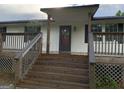 Cozy front porch with wooden stairs and railings leading to the entrance of the home at 276 Oakland Rd, Mcdonough, GA 30253